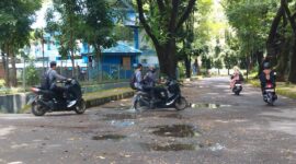 Jalanan bolong dengan genangan air dan lumpur, (Foto: Ayu Amalia.)