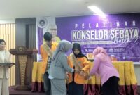Kepala UPT LBK dan Wakil Rektor I saat menyematkan selempang pada calon konselor sebaya, (Foto: Novita Febriyanti)