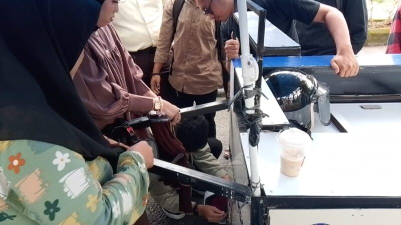 Foto beberapa orang yang sedang memperbaiki gerobak kopi yg rusak akibat cekcok antara mahasiswa, (Foto: Muh Apdal Adriansyah)