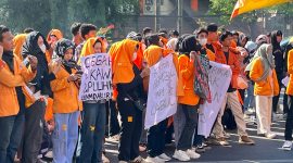 Potret massa aksi BEM memegang spanduk sebagai tanda protes (Foto: Nur Hafizha)