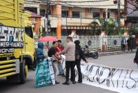 Potret polisi yang menghentikan pertikaian antara pengendara motor dengan massa aksi, (Foto: Winda Pratiwi Agus Tina)