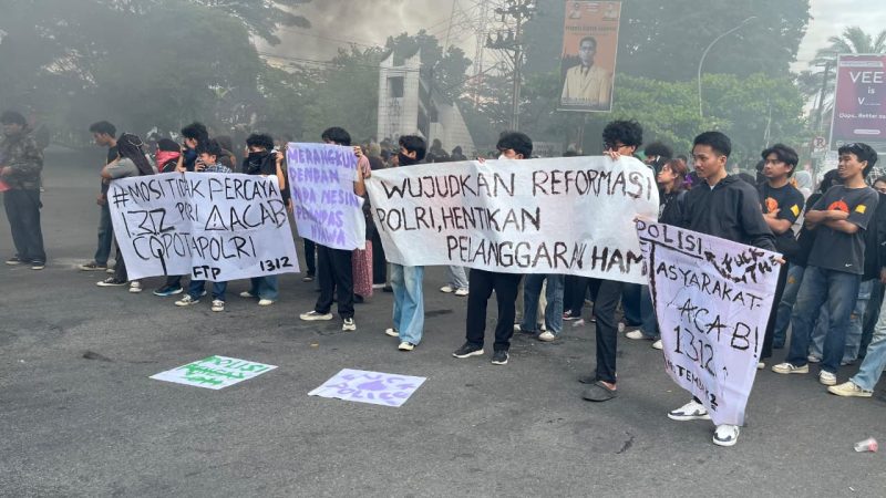 Potret Mahasiswa Membentangkan Spanduk Berisi Tuntutan Saat Aksi Demonstrasi. (Foto: Winda Pratiwi Agus Tina)